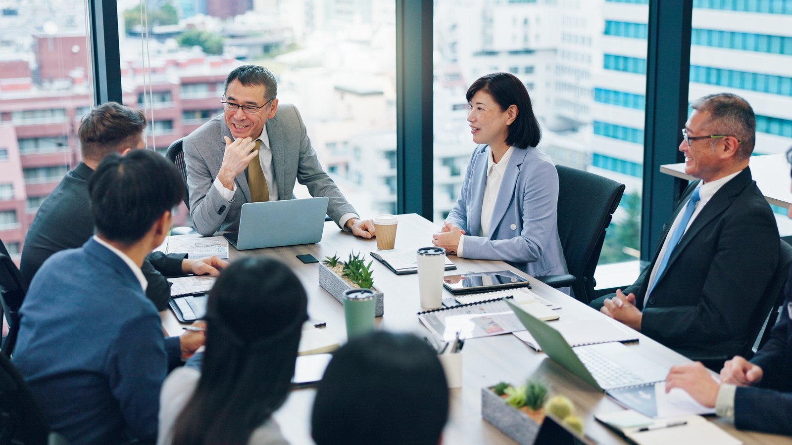 会議室で議論する日本企業の管理職たち